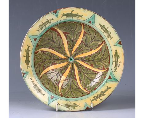 A Della Robbia pottery circular dish, circa 1900, decorated by Harry Pearce, with an incised foliate design, factory marks an