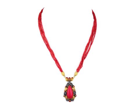 With a pendant featuring a pear-shaped coral cabochon, mounted in 18K yellow gold and silver, accented by red enamel and smal