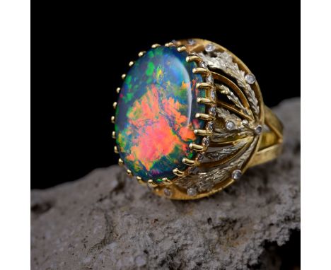 Featuring an oval-shaped black opal cabochon, mounted in 18K yellow gold, enhanced with small brilliant-cut diamonds; opal me