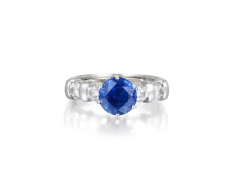 Set with a centered round-cut sapphire, weighing approximately 1.90 carats, flanked by two brilliant-cut diamonds on either s