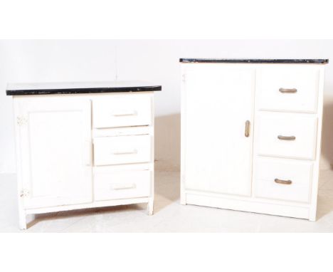 A set of two vintage 20th century circa 1960s white painted wooden kitchen units. Each having a rectangular top with black pa