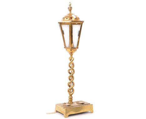 A 20th century brass table lamp in the form of a lantern. The lamp having flambe finial over pierced stars to hood over glaze