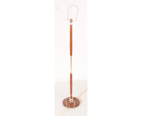 Danish Modern Design - A mid 20th century teak and brass floor standing standard lamp. The lamp featuring a rounded base, wit
