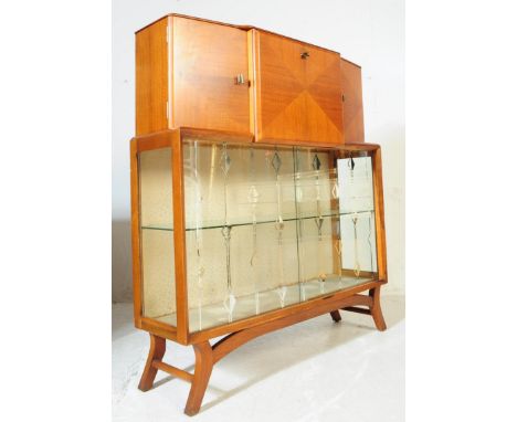 A 1930's Art Deco walnut cocktail drinks cabinet. Raised on splayed legs with twin glass sliding cabinet under a fall front d