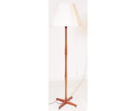 British Modern Design - A mid 20th century teak wood floor standing standard lamp. The lamp raised on a crossed x base, with 