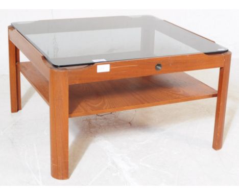 Myer -&nbsp; A 1960's teak framed coffee table of square form with smoked glass top over lower tier. Original button badge to