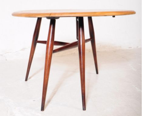 Ercol Furniture - An Ercol retro vintage circa 1970's drop leaf circular coffee - occasional table by Ercol raised on tapered