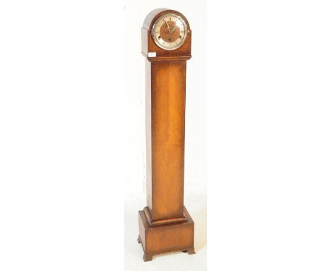 A mid 20th century oak cased granddaughter floor standing clock. Having a Westminster chime, dome top with ebonised roman num