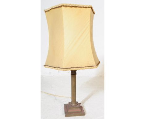 An early 20th century brass table lamp in the form of a Corinthian order column having acanthus to top over reeded shaft over