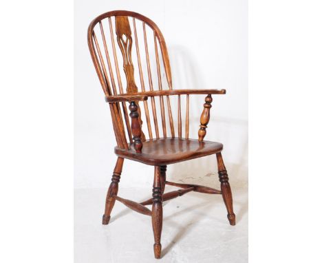 A 19th century beech and elm comb back Windsor chair. The chair having hoop back with central pierced back splat surrounded b