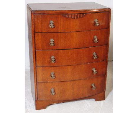 A vintage 20th century post war Art Deco oak veneer bow front chest of drawers. With a bank of five graduating drawers. Raise