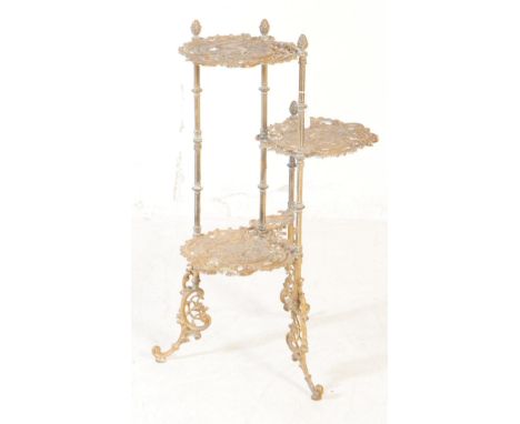 An Art Nouveau inspired brass tiered plant stand. Having three tiers with scrolled foliate work, bird emblem to centre of eac