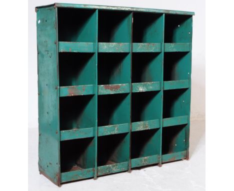 A vintage 20th century painted metal industrial workshop wall hanging cabinet shelving unit. The unit having sixteen pigeon h