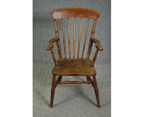 A 19th century elm seated stick back kitchen chair. 