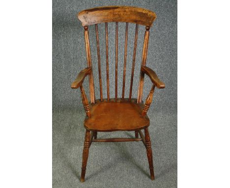 A 19th century elm seated stick back kitchen chair. 