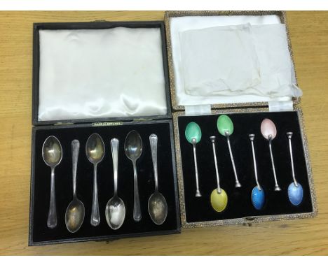 A cased set of enamel and silver teaspoons; together with cased hallmarked silver teaspoons