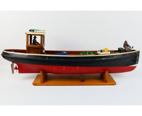 A steam powered model boat. The boat, probably kit built measures approximately 87 cms in length with a beam of 18 cms, and a