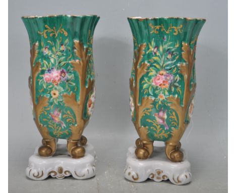 A pair of 19th Century Victorian ceramic vases having fluted rim with hand florals on a green ground with gilt folate support