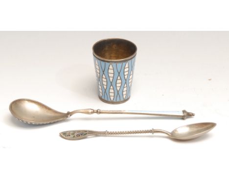 A late 19th century Russian silver and enamel spoon; a similar miniature beaker, in white and blue, gilt interior, 4.5cm; a s