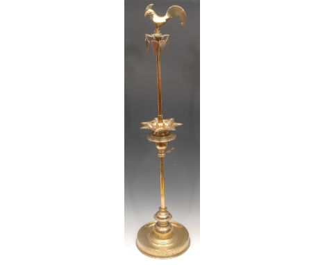 A large Indian brass adjustable puja lamp, cockerel  finial, dished circular base, 93cm high, 19th century 