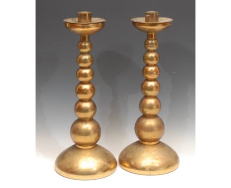 A pair of large brass candlesticks, graduated bobbin stems, removable wax tray, each 42cm high (2) 