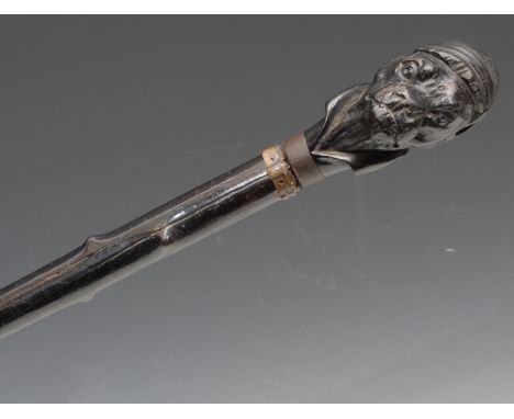 An early 20th century novelty walking stick, the pommel carved as the head of a dog wearing a jockey's cap, ebonised thornwoo