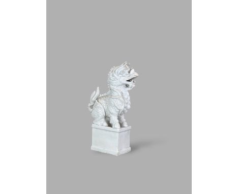 A 'blanc de chine' Kylin Taperstand, Kangxi, the dragon headed beast carved and moulded, sitting on a rectangular plinth with