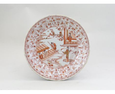 An Iron Red decorated Dish with Figures, Kangxi,, the petal moulded barbed rim, pencilled with flower vignettes, enclosing a 