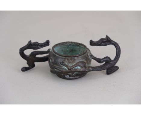 A Bronze Double Dragon Waterpot, the dragons' heads and upper bodies in openwork, while their bodies curl in low relief aroun