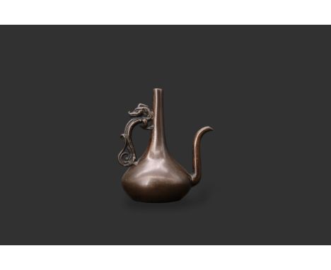 A bronze Ewer shaped Waterdropper, late Ming dynasty, of elegant plain form with slender neck and compressed body, the handle