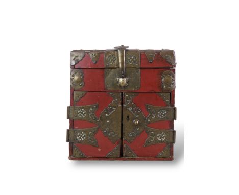 A Korean Red Lacquer Cabinet, Joseon dynasty, with extensive decorative metal mounts on the hinged lid and at the front, whic