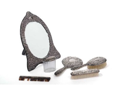 A matched silver dressing table set, in the Victorian style, comprising: a dressing table easel mirror, two brushes, a hand m