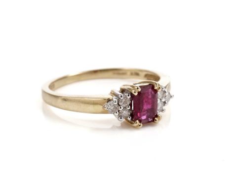 A ruby and diamond ring, the rectangular step cut ruby flanked by trios of round brilliant-cut diamonds, in 18ct yellow gold,
