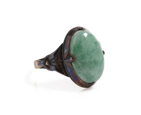 An Art Deco jadeite cabochon dress ring, the oval cabochon approximately 13 x 9mm, in yellow gold, stamped "14K", size K, 3.4