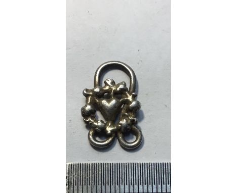 Tudor silver clothes fastener consisting of a heart surrounded by a floral circle. W2g.20.5x13.2mm