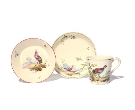 A Mennecy cup and two saucers, c.1755-70, the cup of flared form, all painted with colourful birds perched beside leafy branc