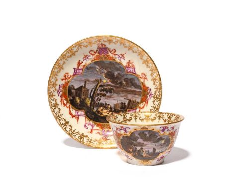 A rare Meissen teabowl and saucer, c.1725-30, unusually painted with night-time harbour scenes, with figures seated around an