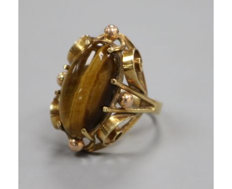 A 585 yellow metal and tiger's eye quartz dress ring, size K.