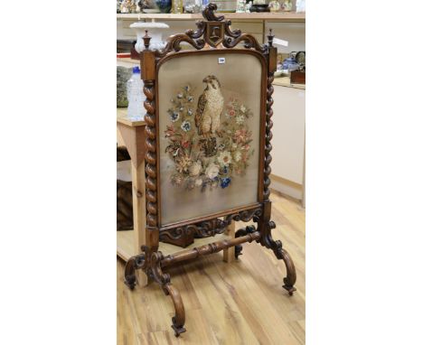 A Victorian carved walnut firescreen with needlework panel of a falcon W.68cm H.133cm