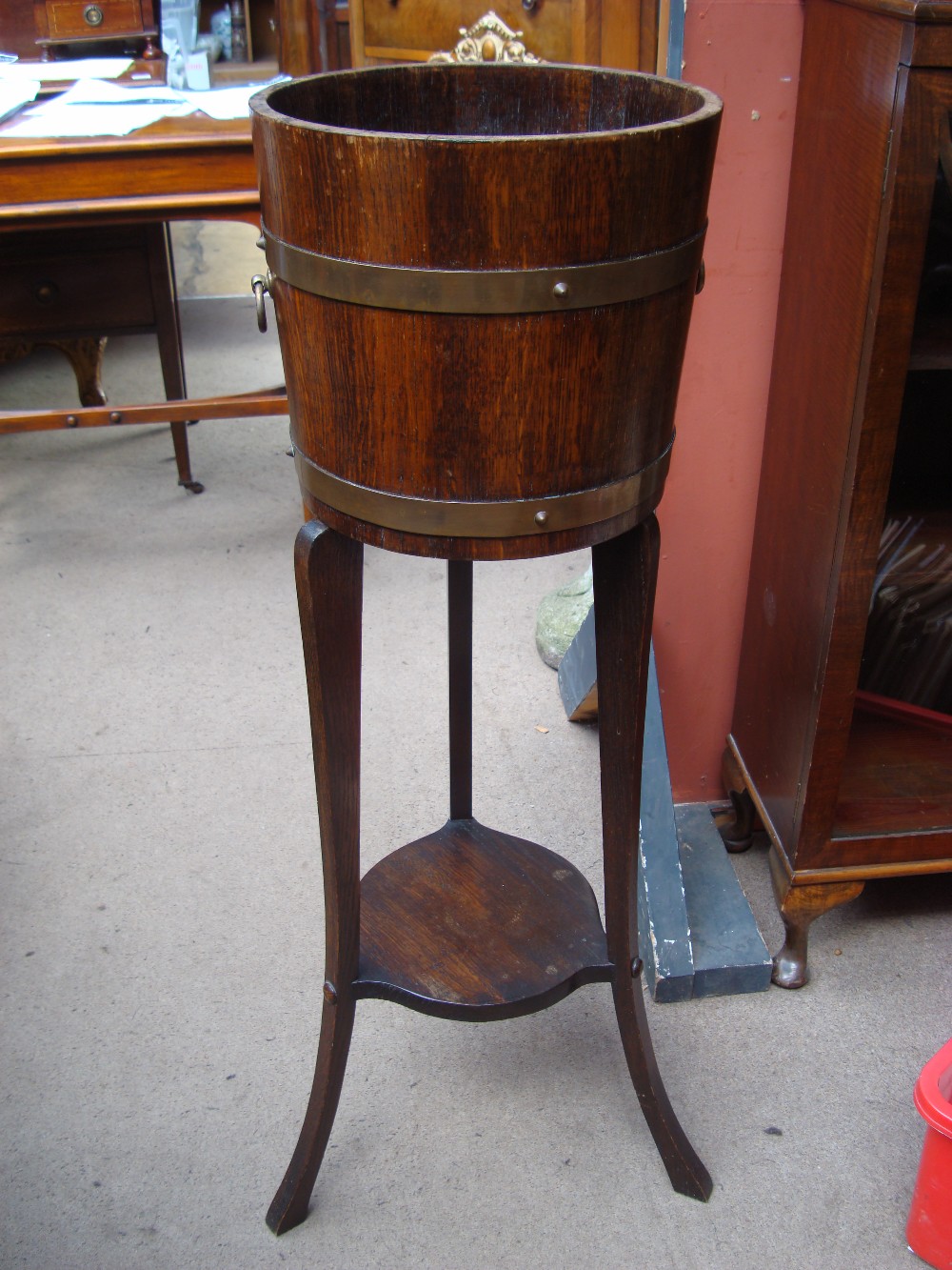 A wooden ice bucket on jardiniere stand.