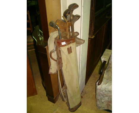 A set of vintage wooden golf clubs together with a golf bag. 