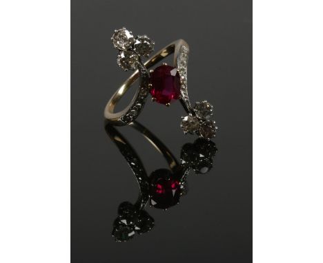 An early 20th century red stone and diamond dress ring. Set with a single red stone, surmounted with six European old cut dia