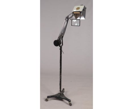 A Horstman Pluslite mid 20th century adjustable counter balanced standard lamp on a tripod caster base.  