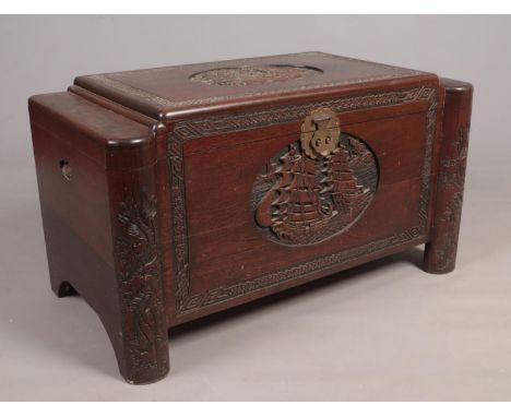 A carved hardwood trunk with camphor wood lining and oriental decoration. Height 57cm Width 103cm Depth 54cm.  Some cracking 