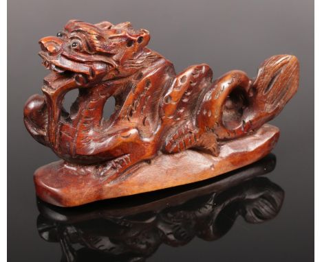 A Japanese box wood Netsuke style signed carving of a Dragon. H: 4.5cm, W: 7cm.  