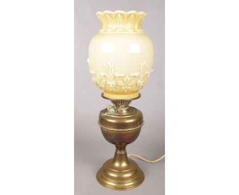 A brass and glass oil lamp converted to electric. With cream coloured shade with floral decoration.  