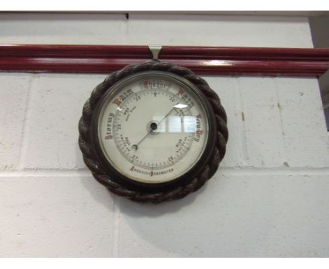A circular aneroid barometer with rope twist detail