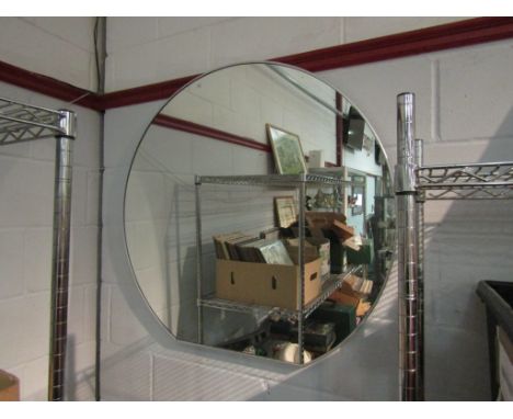 A large modern mirror, circular with a flat base, 95cm diameter