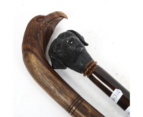 A carved wood walking stick with eagle-head knop, and another with Labrador's head knop 