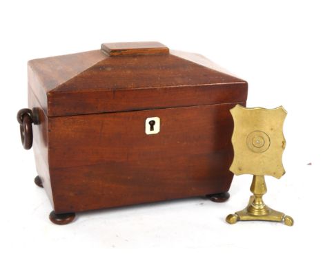 A Regency mahogany sarcophagus tea caddy, and a Georgian brass candle reflector. (2)